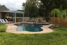 Backyard view of pool and summer kitchen