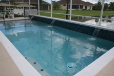 Modern pool with 18 inch raised tile wall and three 12-inch waterfalls