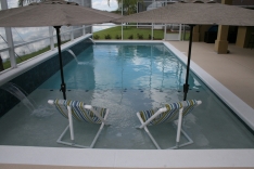 Modern pool with sun shelf and two umbrella holders