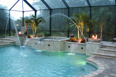 Roman pool with fire pits lit and night lighting